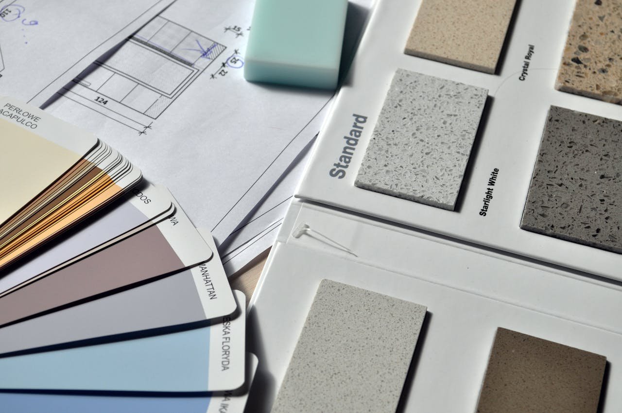 expertise-01 Color palette and material samples for interior renovation projects on a blueprint.